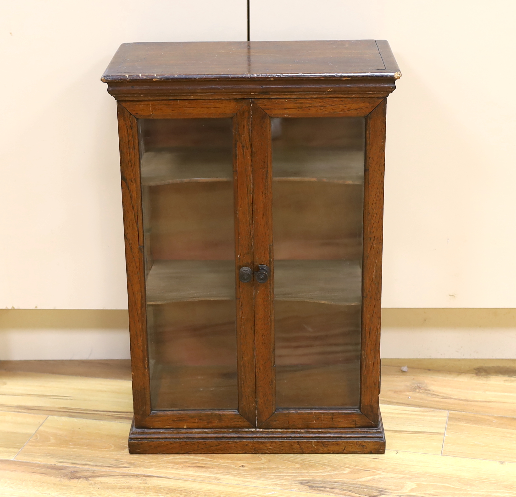 A small early 20th century glazed oak and pine two door shop display cabinet, 65.5 x 45 x 26cm